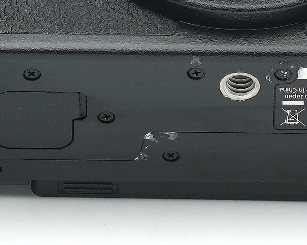 Laptop-Unterseite, schwarzer Kunststoff, Gewindebuchse, verschraubt, Oberflächenkratzer