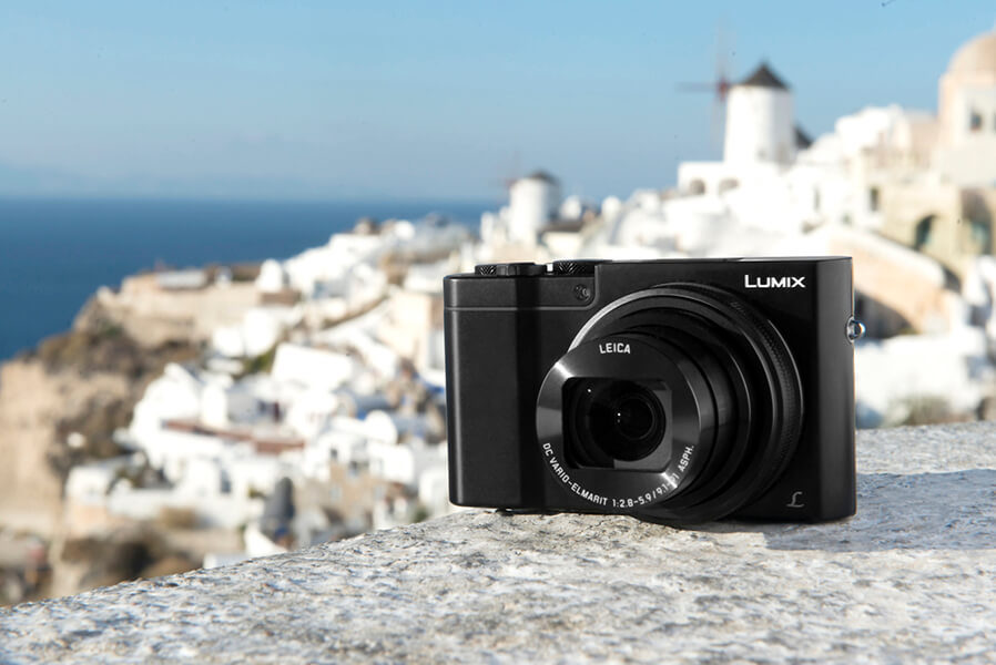 Panasonic LUMIX DMC-TZ101 Kompaktkamera mit LEICA Objektiv auf einer Mauer mit Blick auf Santorin