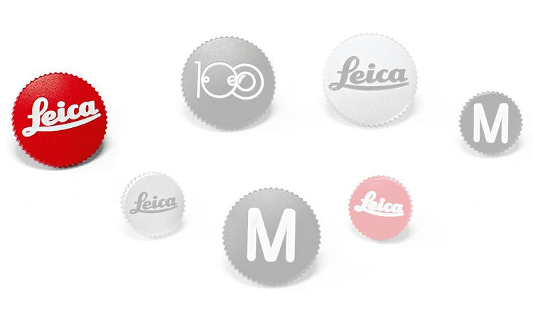 runde Anstecker, Leica-Logo, rot und grau, Buchstabe M, gezackter Rand
