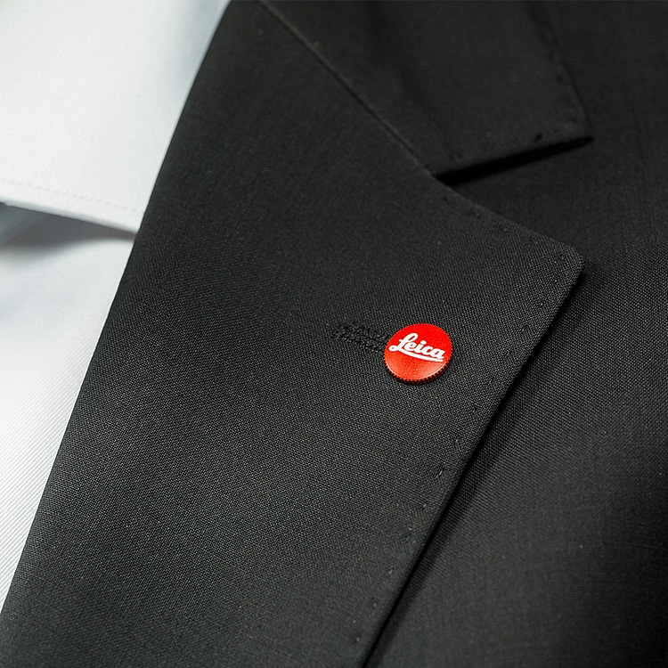 schwarzer Blazer,  fallendes Revers, roter Anstecker, Gewebe