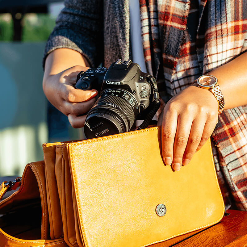 Canon EOS 200D DSLR wird aus einer gelben Handtasche genommen, perfekte Einstiegskamera für unterwegs
